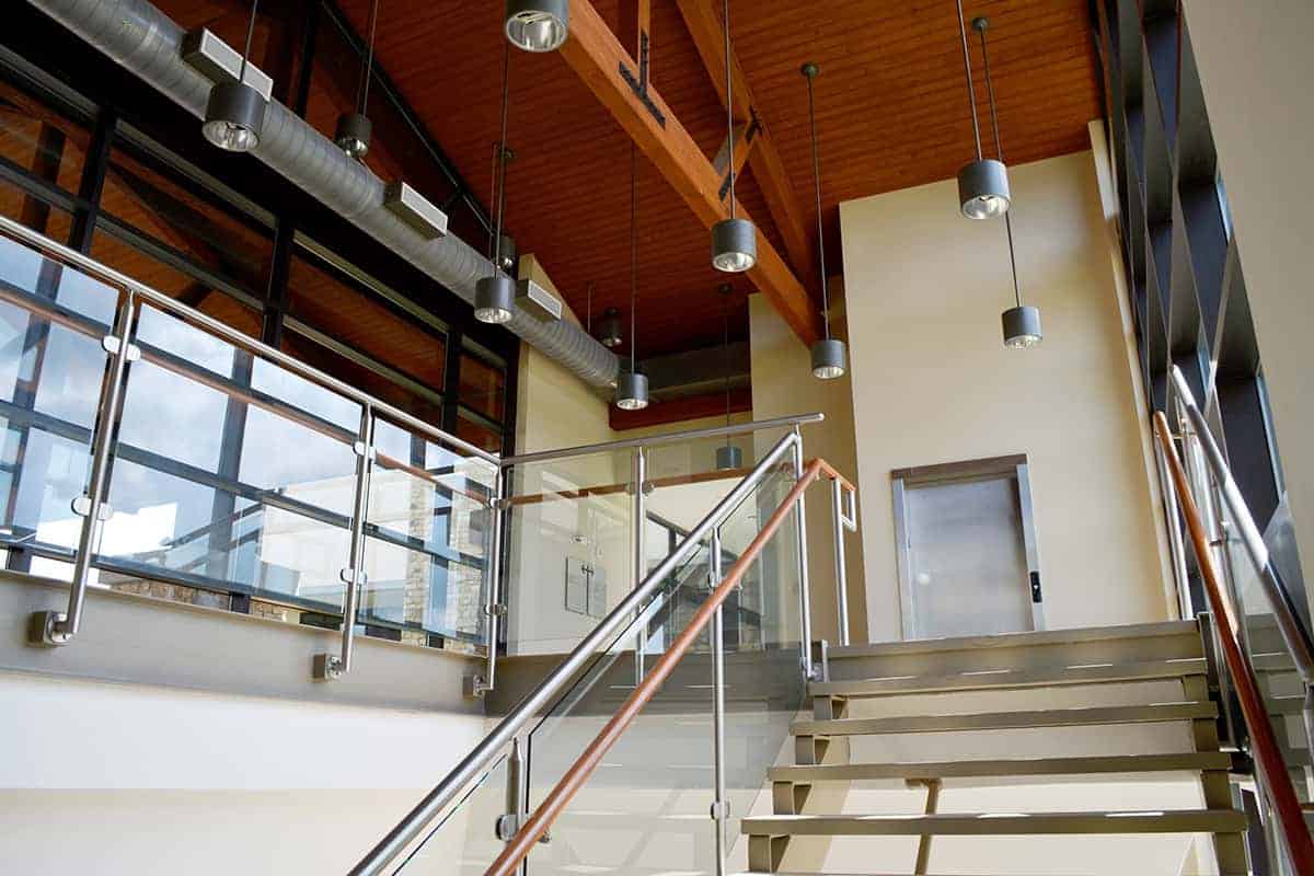 Modern interior staircase with glass and wood design.