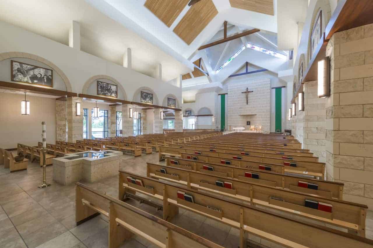 Spacious church interior with wooden pews and altar.