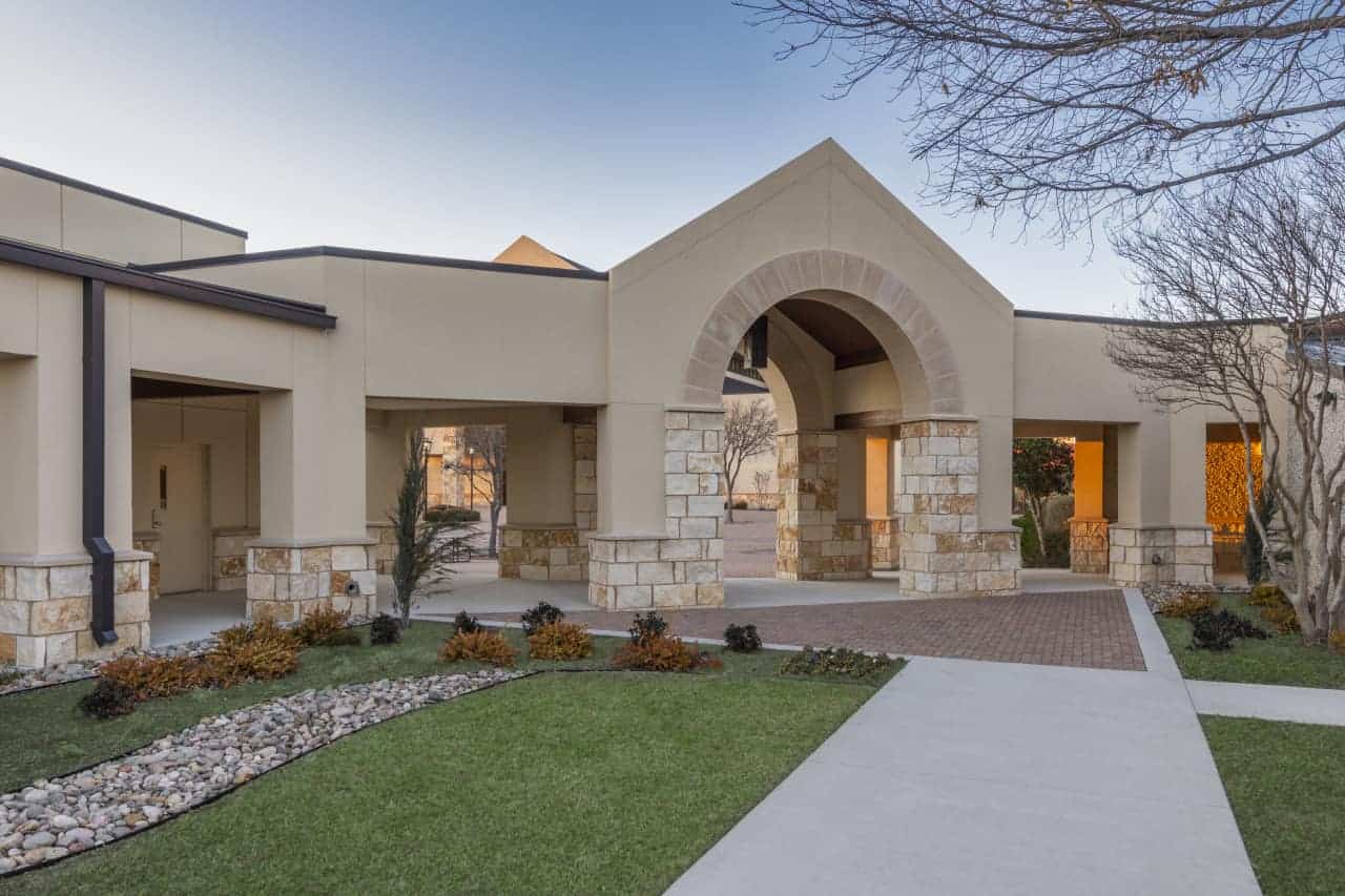 Modern stone building with arches and landscaped garden