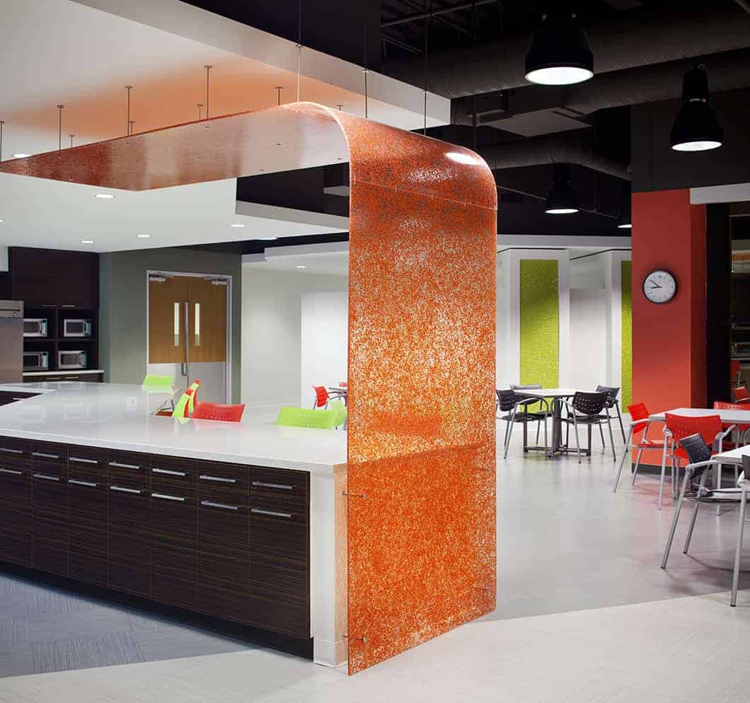 Modern cafeteria with colorful chairs and tables.