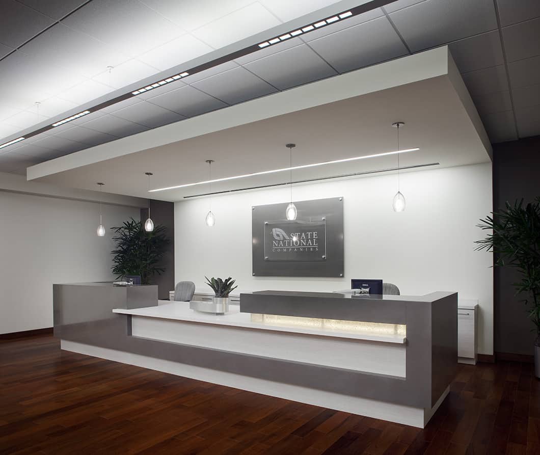 Modern office reception with pendant lights and plants.