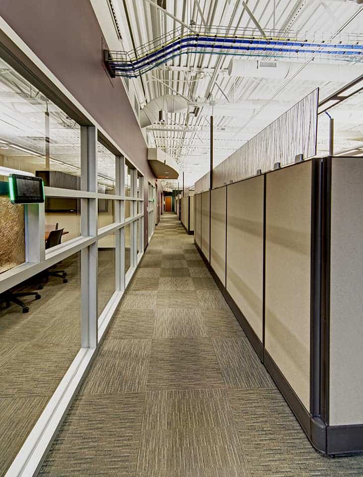 Modern office hallway with cubicles and glass walls