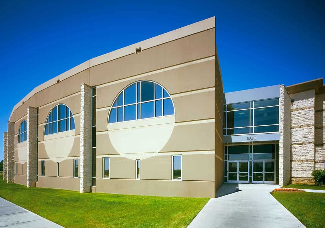 Modern beige building with circular windows.