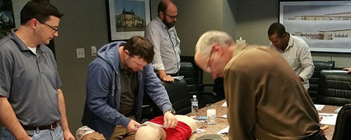 People practicing CPR in a conference room.