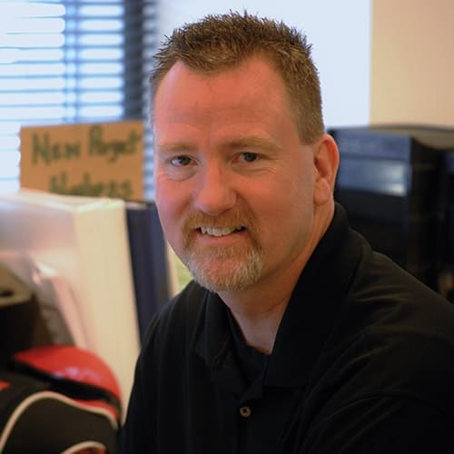 Smiling man in office with goatee and short hair