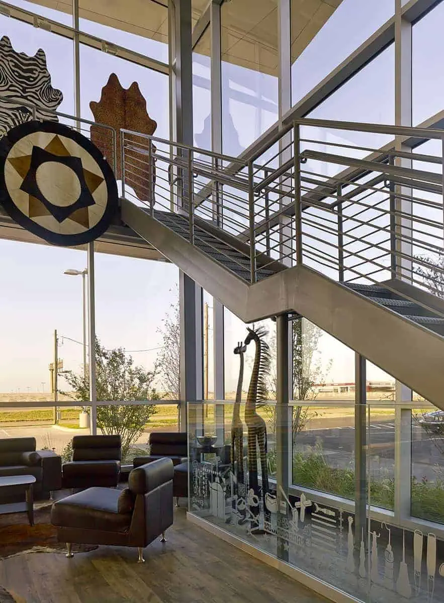 Modern lobby with staircase and giraffe statue.