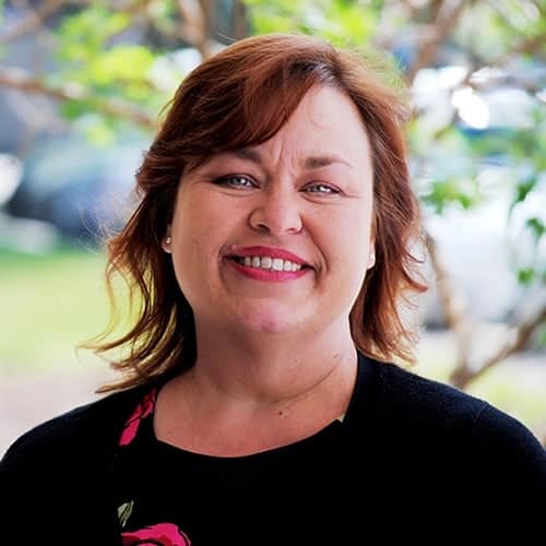 Smiling woman outdoors with blurred background