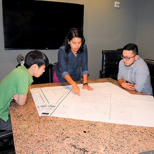 Team reviewing blueprints in a conference room.