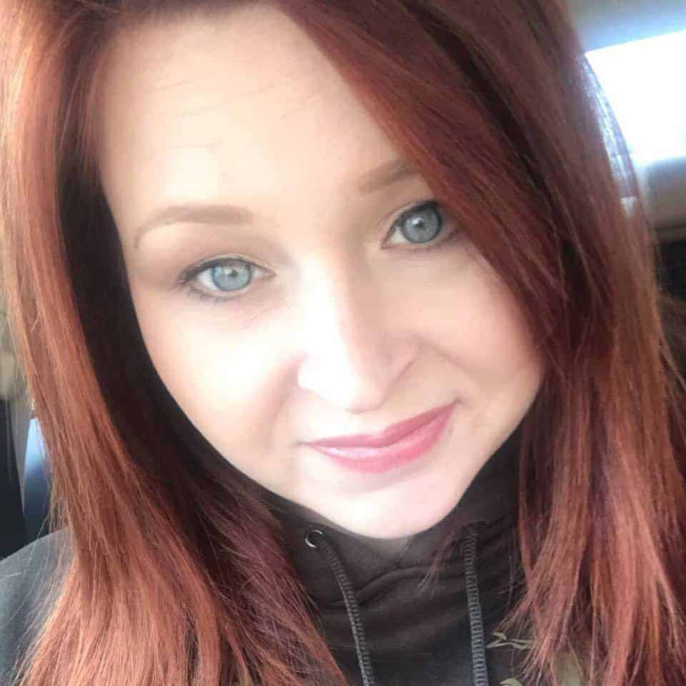 Person with long red hair smiling