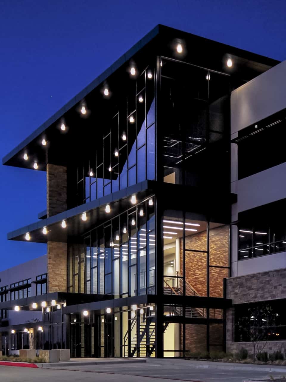 Modern office building with glass facade at night.