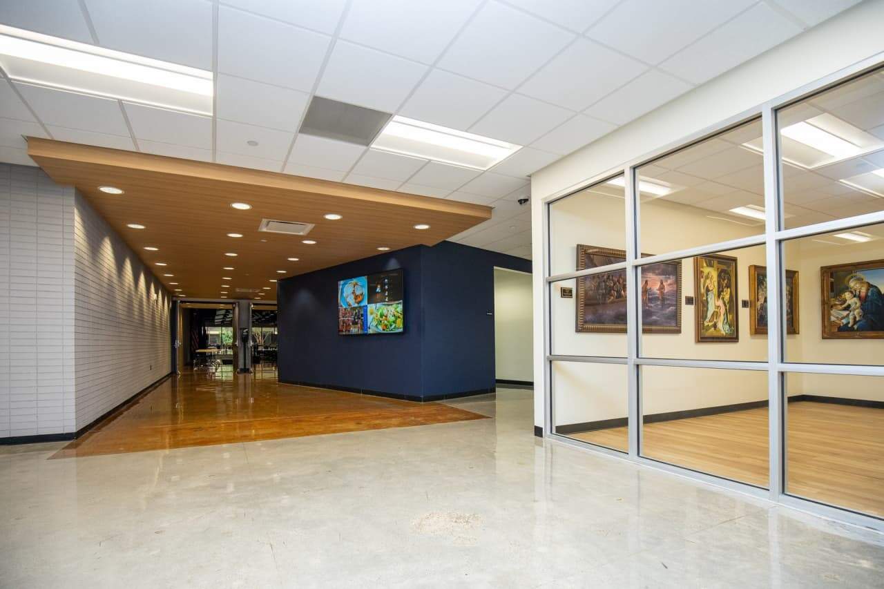 Modern corridor with wooden ceiling and framed artwork.