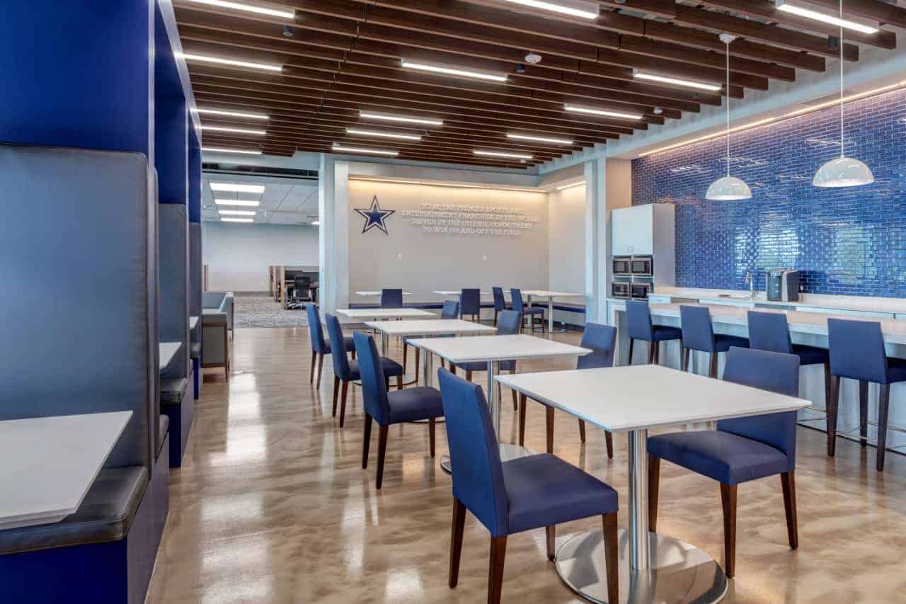 Modern office cafeteria with blue chairs and tables.