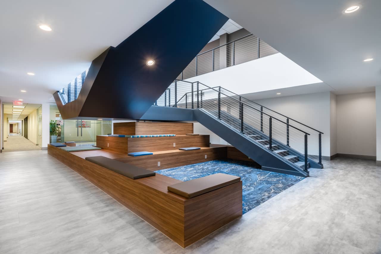 Modern office space with staircase and seating area.