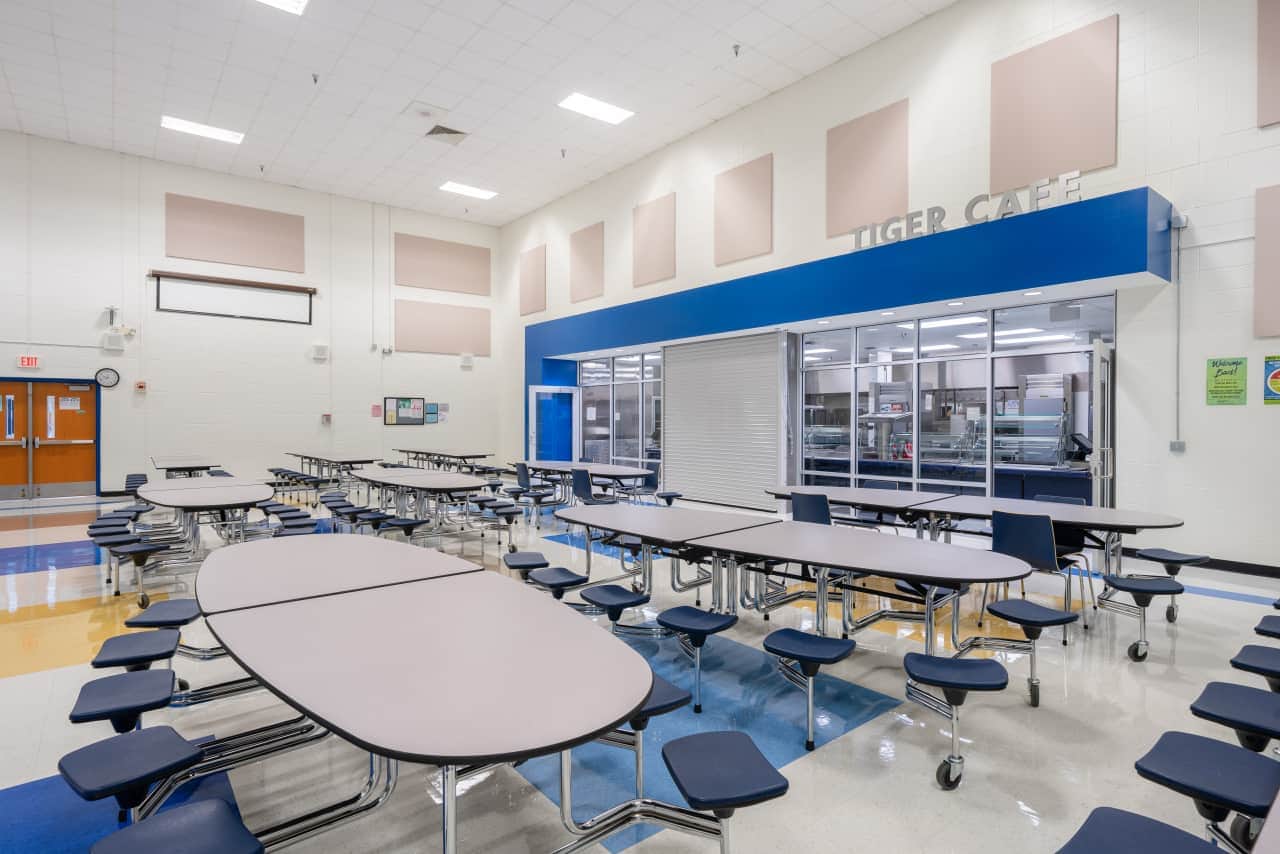 Empty school cafeteria with tables and chairs.