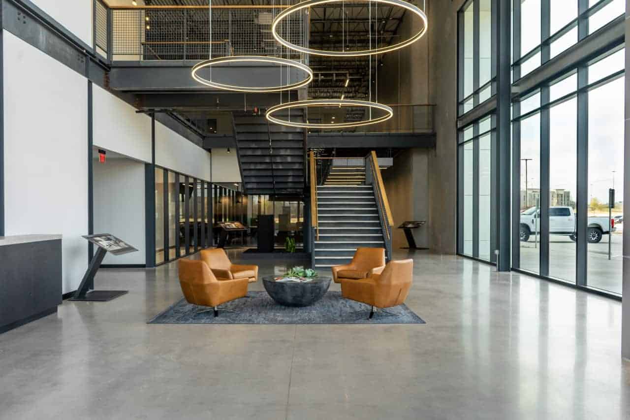 Modern office lobby with seating and staircase.
