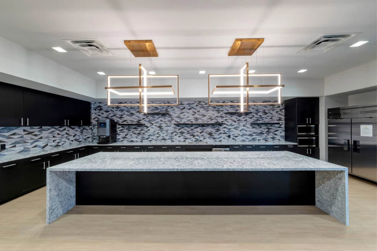 Modern kitchen with geometric backsplash and lighting.