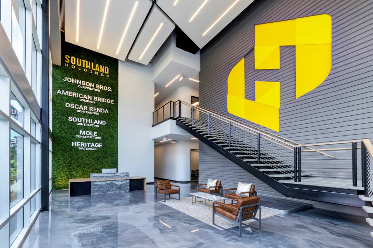 Modern lobby with company logos and staircase.