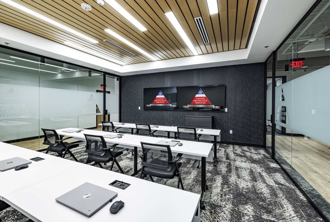 Modern conference room with tables and screens.