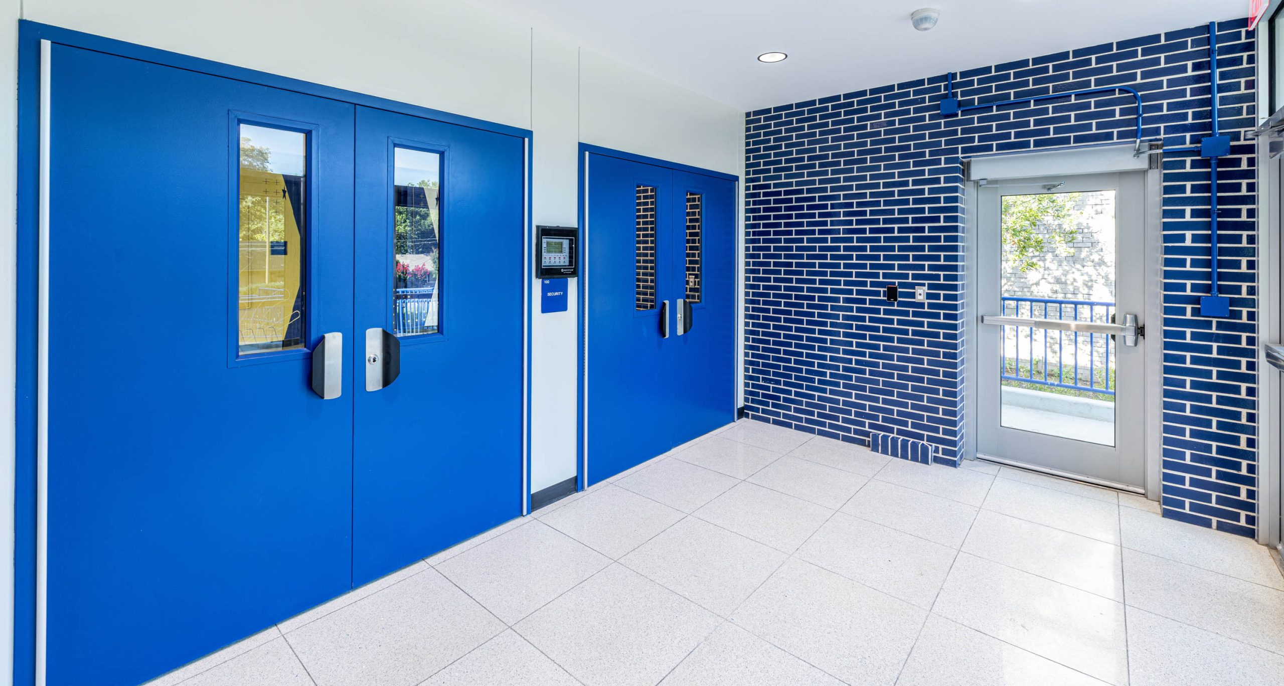 Blue doors and brick walls in hallway.