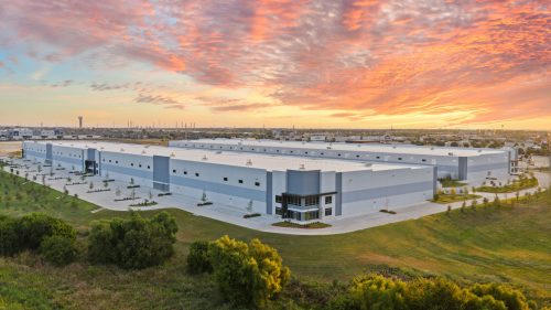 Large industrial warehouse at sunset with colorful sky