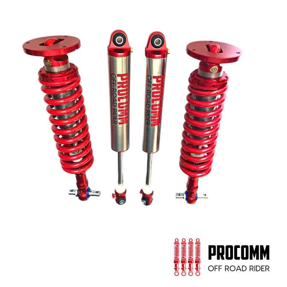 Red Procomp off-road shock absorbers for enhanced vehicle suspension performance.