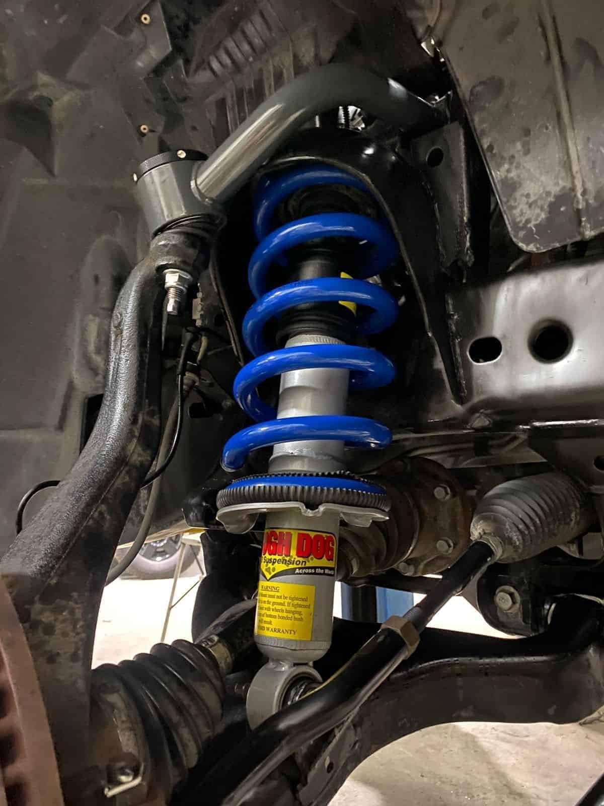 High-performance vehicle suspension shock absorber with coil spring.