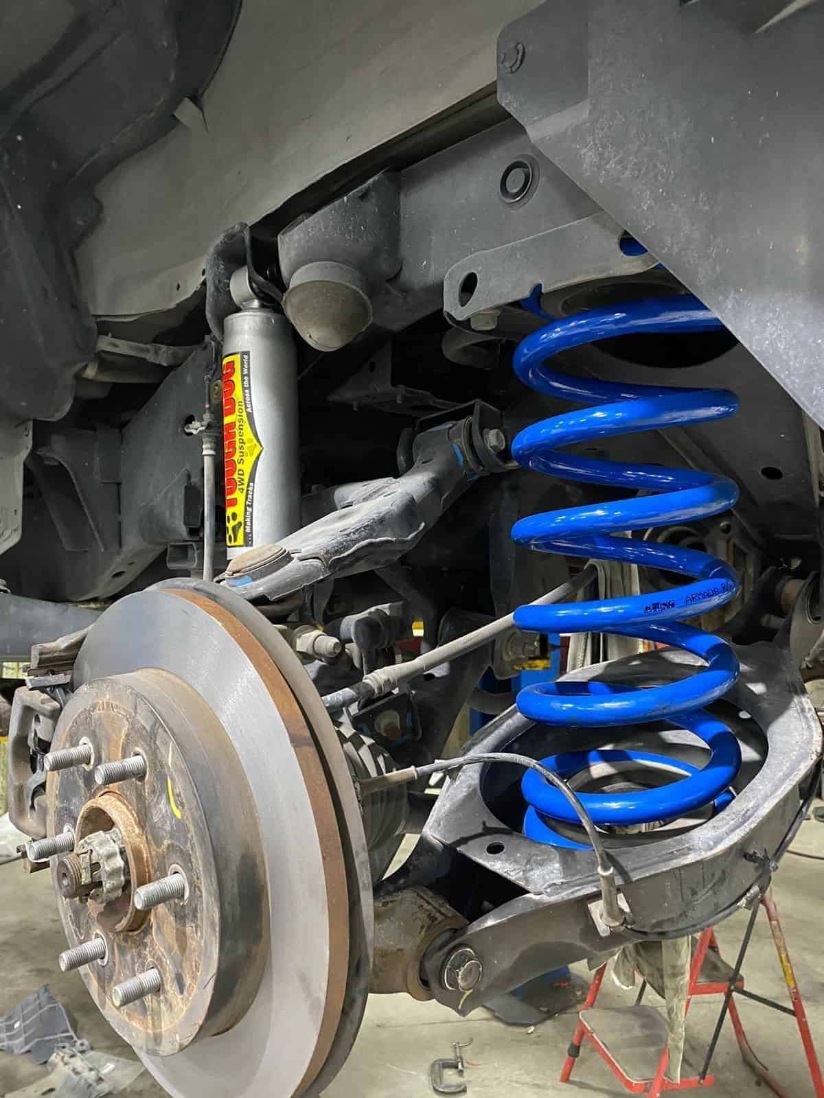 Vehicle suspension system with blue coil spring and shock absorber.