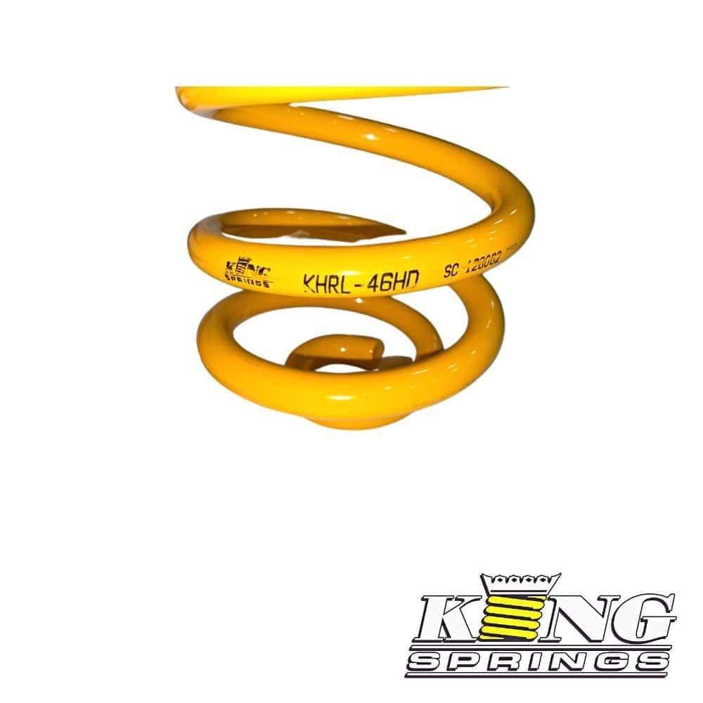 Yellow coil spring for industrial or mechanical use, isolated on white background.
