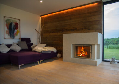 Accogliente soggiorno con camino e vista sul verde, atmosfera calda e naturale.