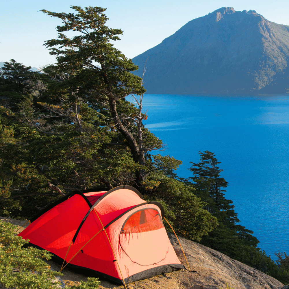 Camping Insurance Quote Red tent near lake and mountain.