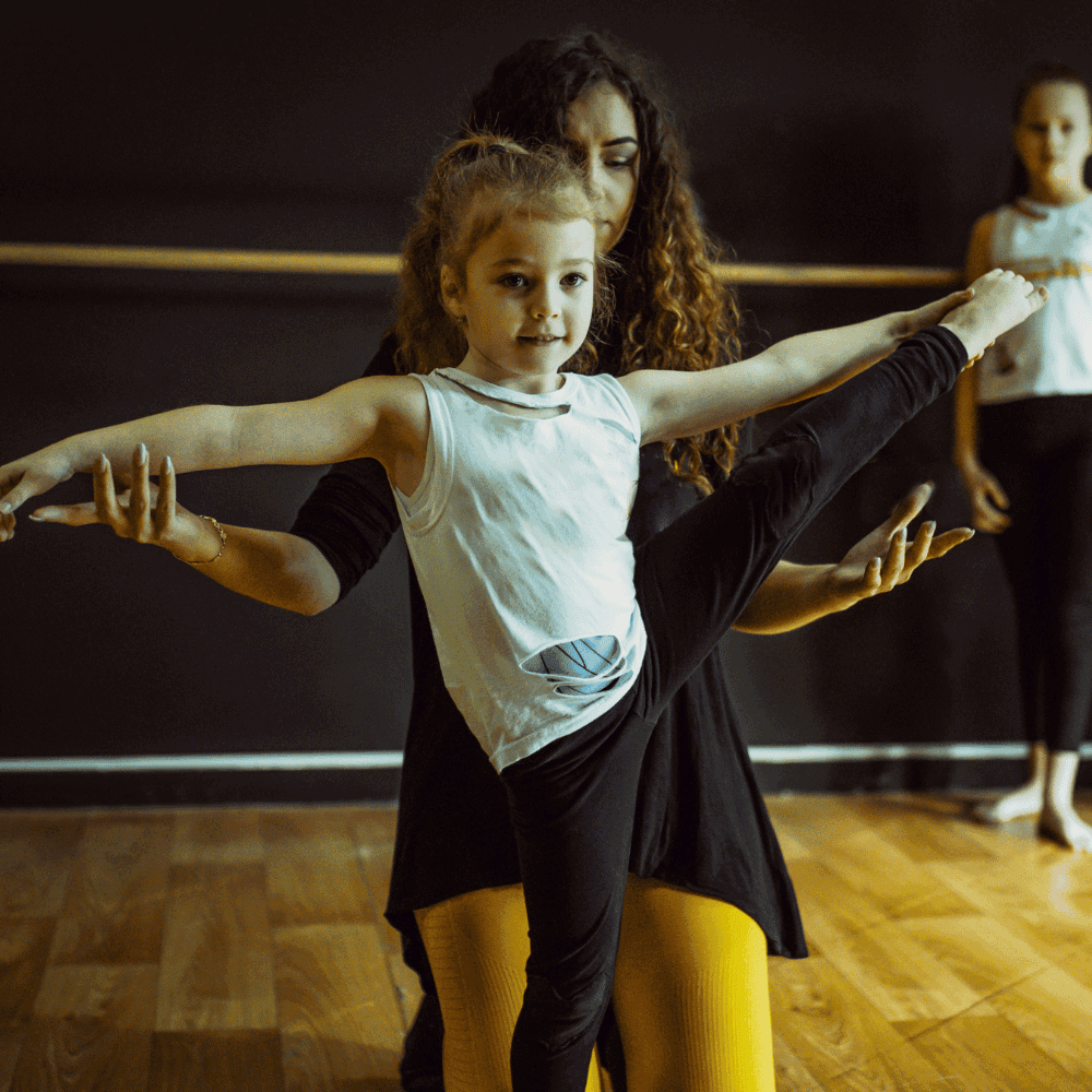 Child practicing instructor-assisted ballet.