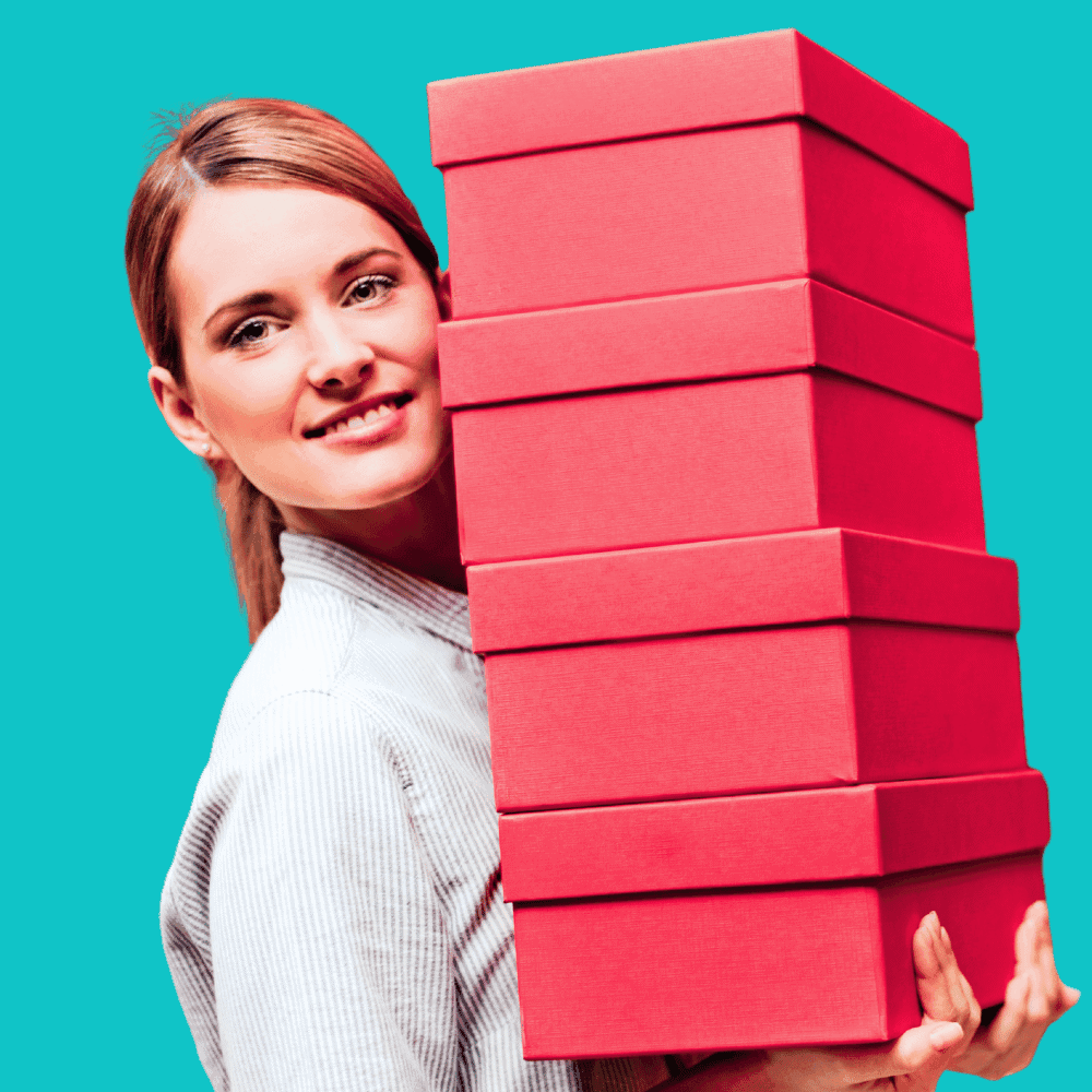 Femme portant des boîtes rouges empilées.