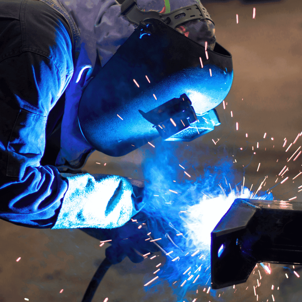 Industrial Welding Insurance Quote Welder working with sparks and helmet.