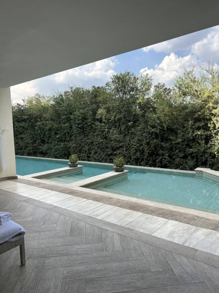 The swimming pool at the spa at the Four Seasons the Westcliff Hotel, with green trees in the background.