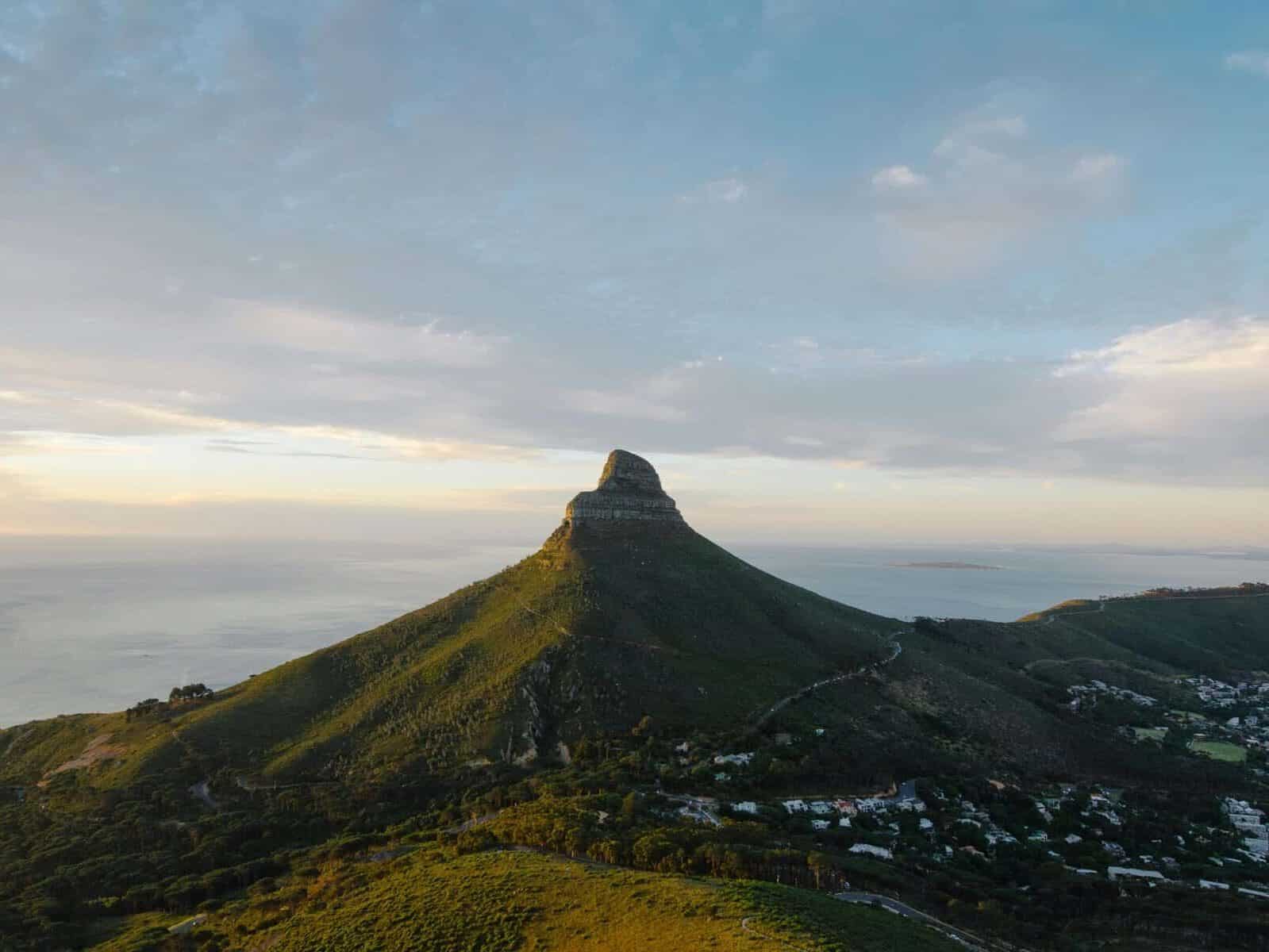 Lion's Head in Cape Town, with Signal Hill in the background, and soft blue cloudy skies.  Photo: Tomas Wells via Pexels.