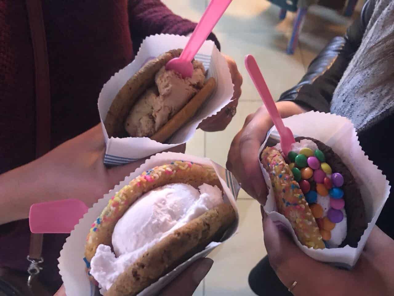 Three girls holding ice cream sandwiches from Crumbs and Cream in Cape Town.  Girls' trips to Cape Town require ice cream.