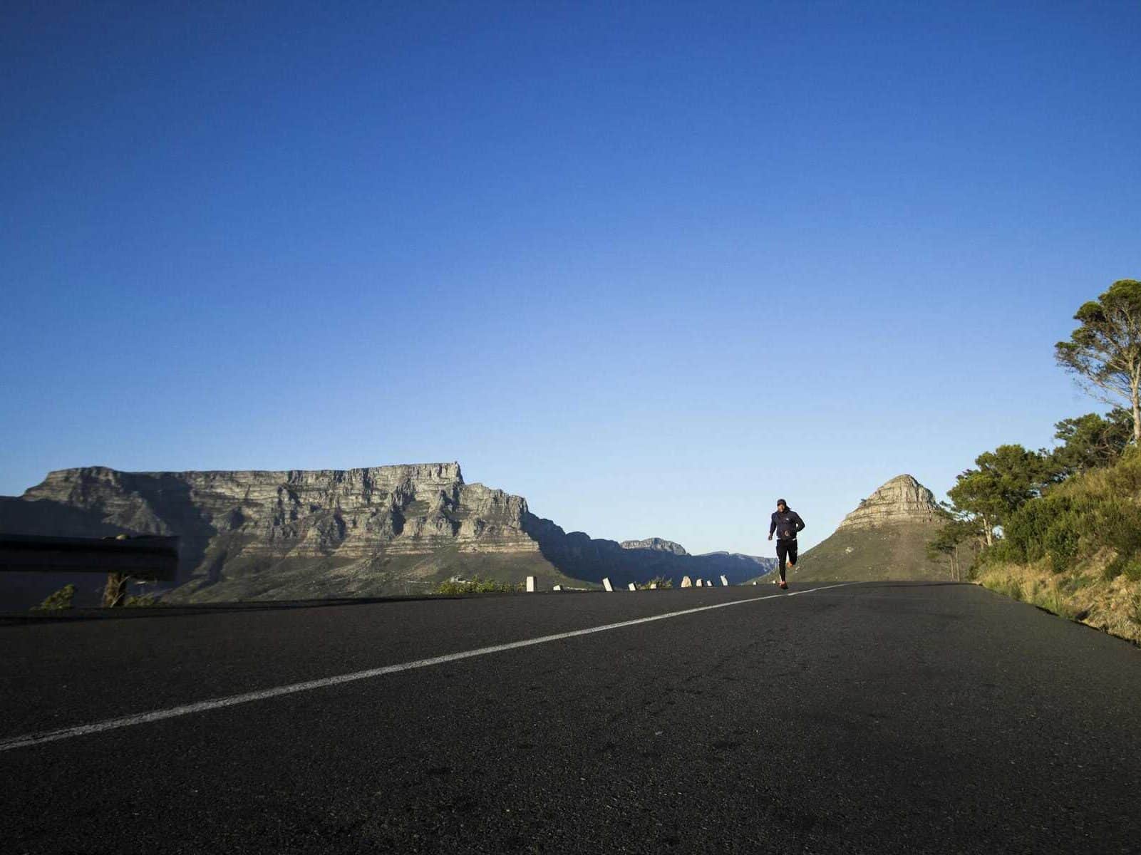 Man jogging along a scenic road with Table Mountain view in Cape Town.  Photo: Tembela Bohle via Pexels.