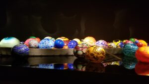 A row of colorful eggs are displayed on a table.
