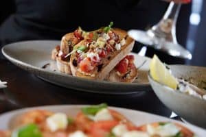 Fresh gourmet bruschetta with tomato, basil, and feta on toasted bread at Bella Vita NZ.