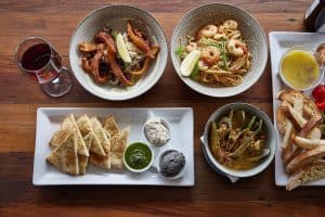 Delectable seafood pasta dishes with prawns and squid served with crispy garlic bread.