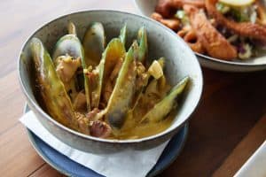 Fresh green-lipped mussels in creamy sauce at Bella Vita NZ restaurant.