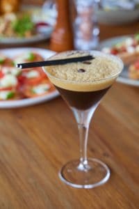 Rich coffee cocktail served in a martini glass with a foamy crema topping and coffee beans, perfect for indulgent occasions.
