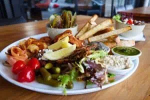 Fresh seafood platter with grilled prawns, oysters, salad, fries, and piquant sauces at Bella Vita NZ.