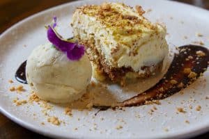 Delicious layered vanilla and chocolate dessert with ice cream and edible flower garnish.