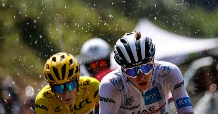 Ciclismo professionale, atleti in gara su strada con caschi e occhiali sportivi durante una competizione. Evento di ciclismo su strada in ambienti naturali, focalizzato su velocità, sport e passione per le due ruote.