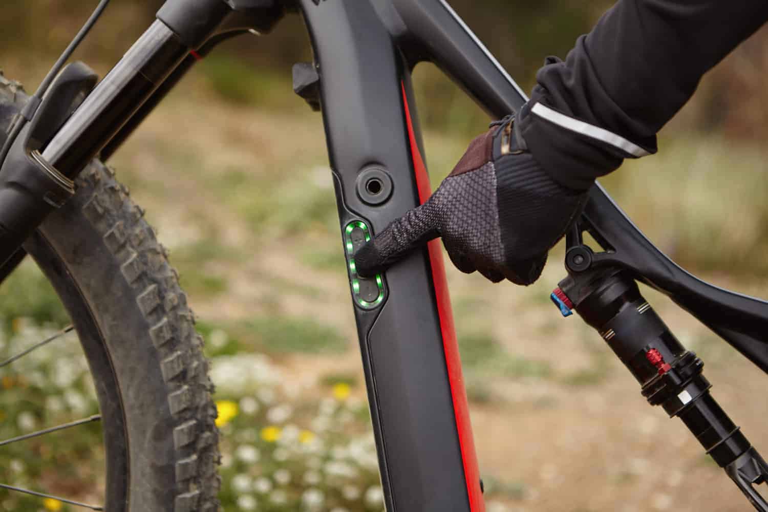 Bici elettrica mountain bike con display digitale e sospensioni su sentiero naturale in campagna.