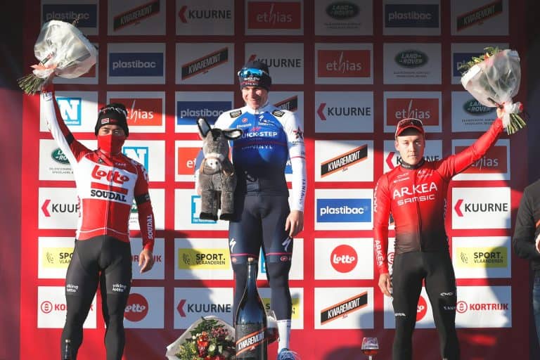 Vincitore di ciclismo sul podio con medaglie e fiori, celebre evento sportivo con sponsor e supporter.