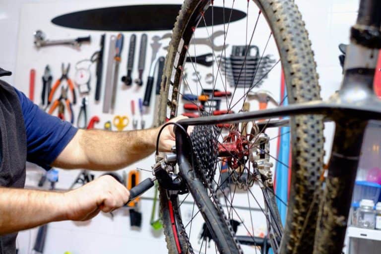 Riparazione bicycle da strada, officina di bici con attrezzi professionali e telaio. Manutenzione e sostituzione componenti, servizio di riparazione bici per ciclisti appassionati e sportivi.