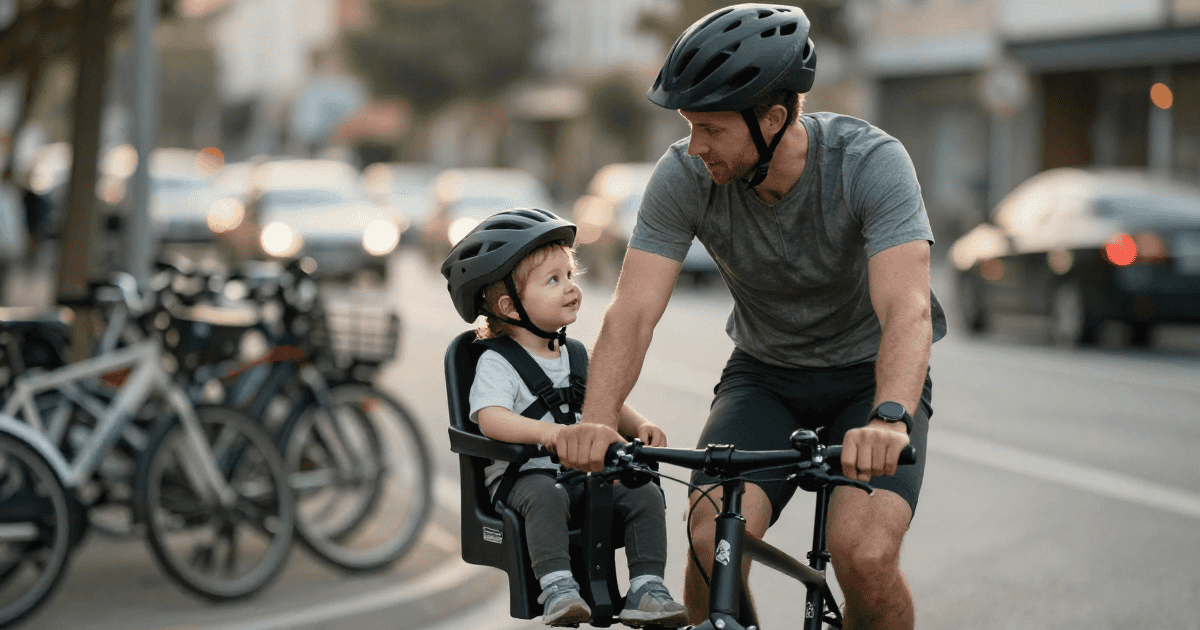 Ciclista con bambino su seggiolino anteriore