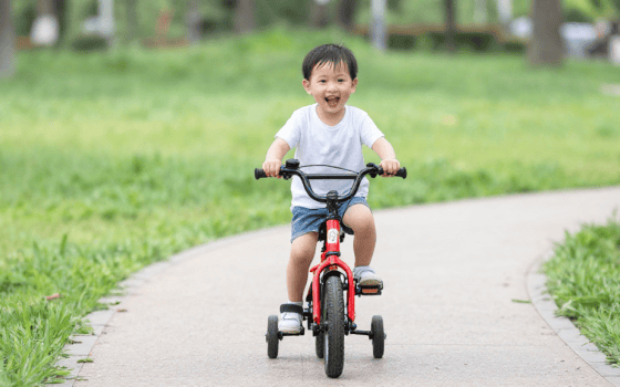bici bambino 3 anni su percorso nel parco con rotelle laterali